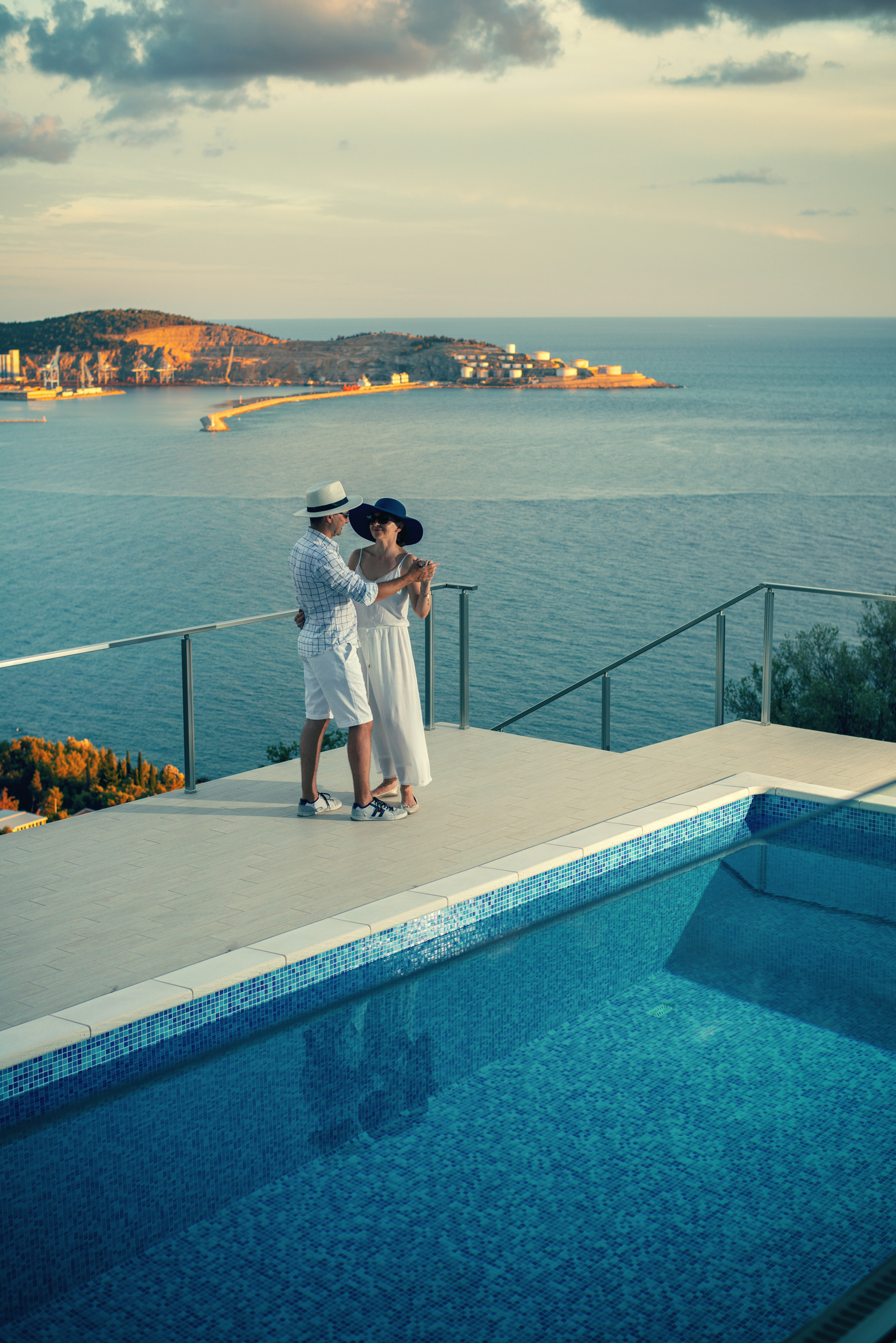 Happy couple dancing by the poolside